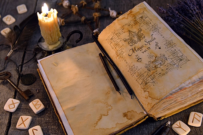 Grimoire surrounded by runes and candles